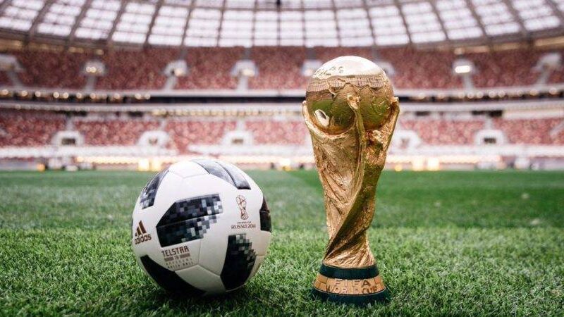 world cup trophy and soccer ball on field