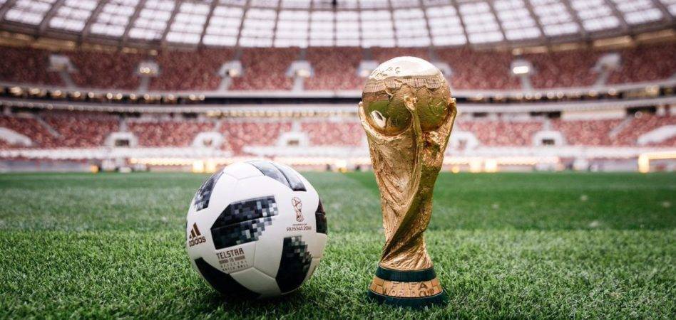 world cup trophy and soccer ball on field